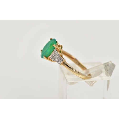 95 - A 9CT GOLD GEM SET RING, designed with a four claw set oval cut green stone, flanked with stepped sh... 