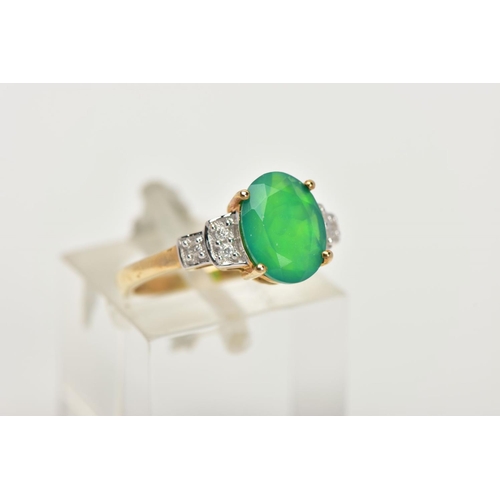 95 - A 9CT GOLD GEM SET RING, designed with a four claw set oval cut green stone, flanked with stepped sh... 