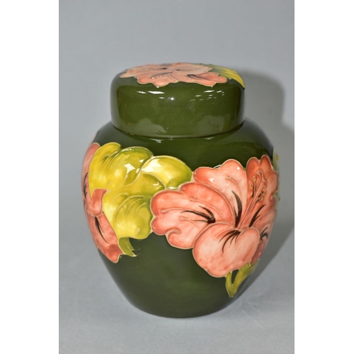 475 - A MOORCROFT POTTERY GINGER JAR AND COVER DECORATED IN FLORAL HIBISCUS ON A GREEN GROUND, the cover b... 