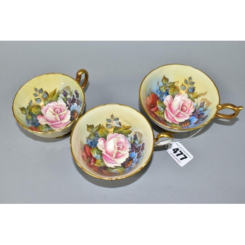 477 - THREE AYNSLEY CABBAGE ROSE TEA CUPS DECORATED BY J.A. BAILEY, comprising pattern no. 1028 with solid... 