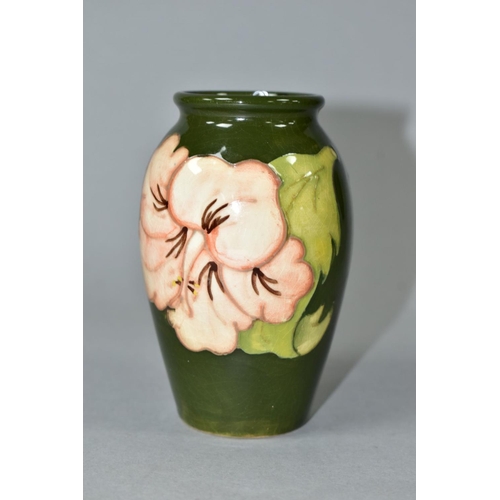 494 - A MOORCROFT POTTERY BALUSTER VASE DECORATED WITH CORAL HIBISCUS ON A GREEN GROUND, impressed marks, ... 