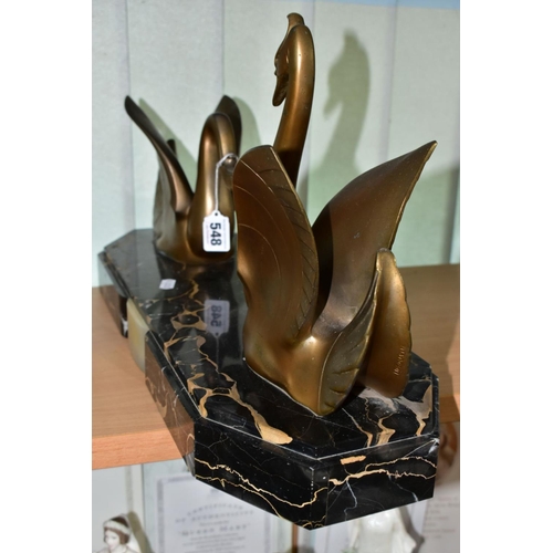 548 - AN ART DECO STYLE SCULPTURE OF TWO GILT METAL SWANS ON A SHAPED RECTANGULAR MARBLE PLINTH, after Mou... 