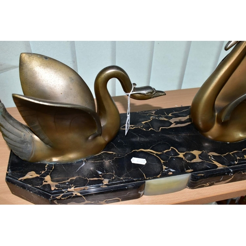 548 - AN ART DECO STYLE SCULPTURE OF TWO GILT METAL SWANS ON A SHAPED RECTANGULAR MARBLE PLINTH, after Mou... 