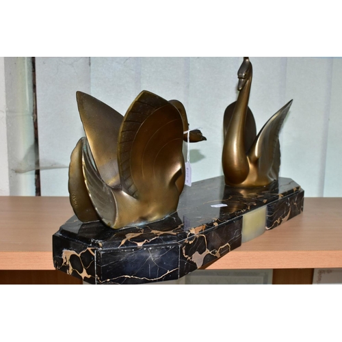 548 - AN ART DECO STYLE SCULPTURE OF TWO GILT METAL SWANS ON A SHAPED RECTANGULAR MARBLE PLINTH, after Mou... 