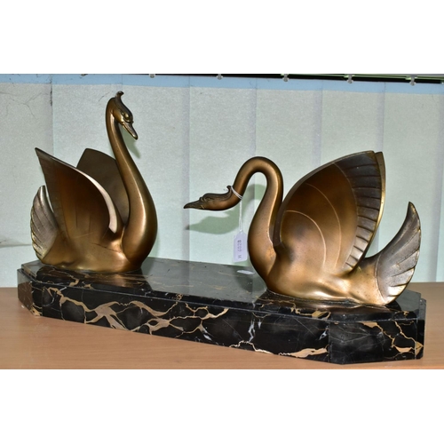 548 - AN ART DECO STYLE SCULPTURE OF TWO GILT METAL SWANS ON A SHAPED RECTANGULAR MARBLE PLINTH, after Mou... 