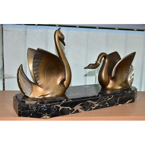 548 - AN ART DECO STYLE SCULPTURE OF TWO GILT METAL SWANS ON A SHAPED RECTANGULAR MARBLE PLINTH, after Mou... 