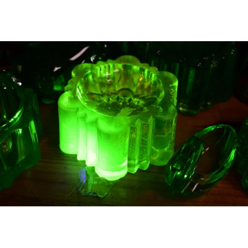 570 - A GROUP OF GREEN, BROWN AND URANIUM GLASSWARES, to include pressed glass furniture rests/piano insul... 