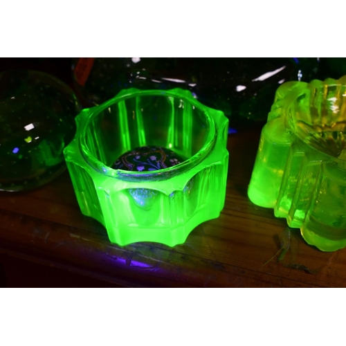 570 - A GROUP OF GREEN, BROWN AND URANIUM GLASSWARES, to include pressed glass furniture rests/piano insul... 