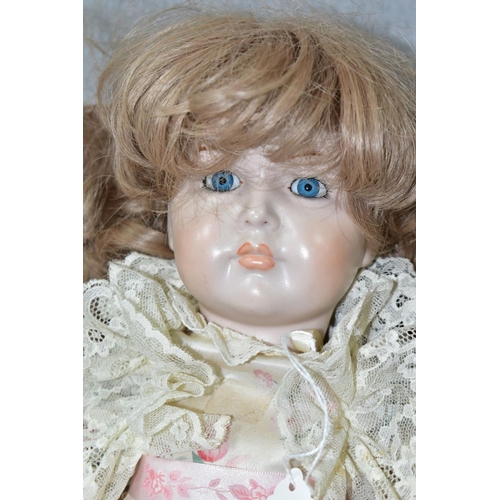 600 - A MODERN BISQUE HEAD DOLL, nape of neck marked '70', fixed blue glass eyes, painted lashes, closed m... 