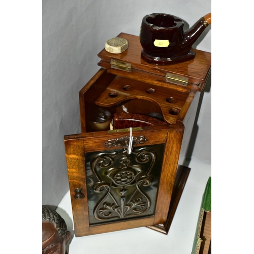 612 - AN OAK PIPE SMOKERS CABINET WITH ART NOUVEAU METAL PANEL INSET TO DOOR, together with smoking relate... 