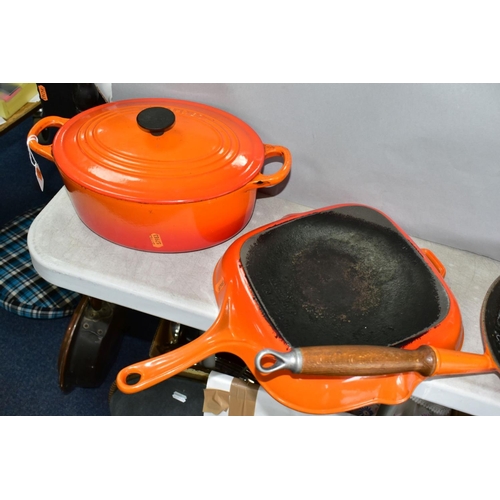 647 - THREE PIECES OF LE CREUSET AND SIMILAR CAST IRON COOKWARES, comprising a Le Creuset oval casserole i... 