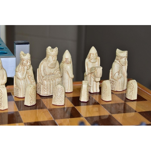 747 - AN ISLE OF LEWIS STYLE CHESS SET, with wooden board 49.5cm square, cast resin cream and black pieces... 