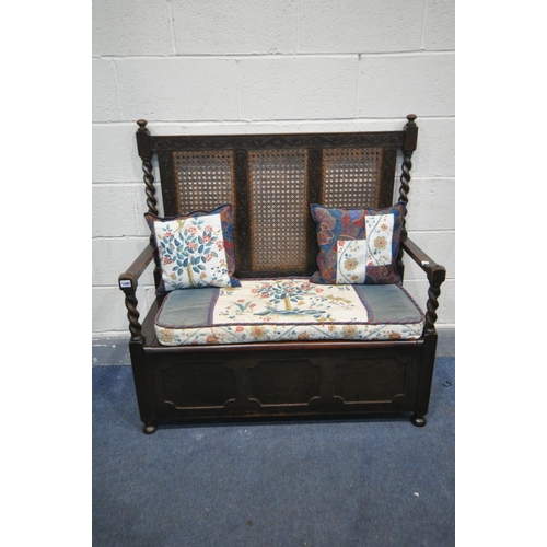 1390 - AN EARLY 20TH CENTURY OAK HALL SETTLE, with bergère back, barley twist supports, open armrests and h... 