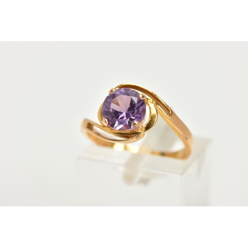 11 - A YELLOW METAL GEM SET RING, a circular cut purple stone assessed as a synthetic colour change sapph... 