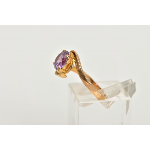 11 - A YELLOW METAL GEM SET RING, a circular cut purple stone assessed as a synthetic colour change sapph... 