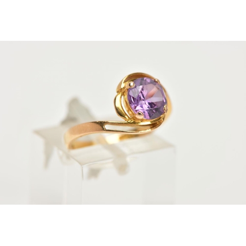 11 - A YELLOW METAL GEM SET RING, a circular cut purple stone assessed as a synthetic colour change sapph... 