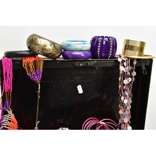 156 - A BLACK TIN FILLED WITH COSTUME JEWELLERY, to include various bangles, beaded necklaces, etc