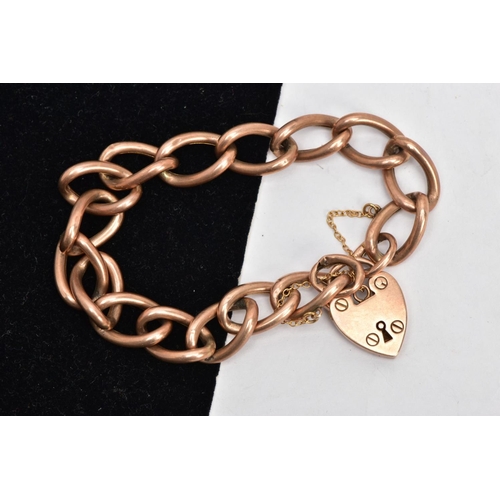 23 - AN EARLY 20TH CENTURY ROSE GOLD CHARM BRACELET, large oval hollow links, fitted with a heart padlock... 