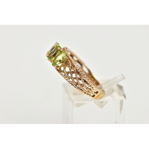 39 - A 9CT GOLD PERIDOT RING, three oval cut peridots prong set in yellow gold, leading on to an open wor... 