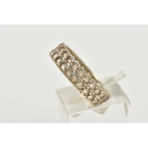 84 - A WHITE METAL FULL ETERNITY RING, wide band set with two rows of colourless spinels, approximate wid... 