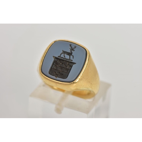 87 - A MODERN 18CT GOLD HARD STONE SIGNET RING, the hardstone carved to depict a coat of arms with stag, ... 