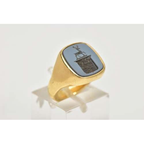 87 - A MODERN 18CT GOLD HARD STONE SIGNET RING, the hardstone carved to depict a coat of arms with stag, ... 