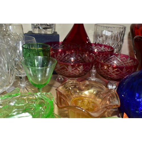 563 - A GROUP OF COLOURED AND CLEAR GLASSWARES, to include a cranberry glass jug with white rim detail and... 