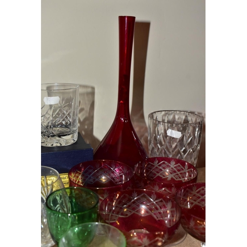 563 - A GROUP OF COLOURED AND CLEAR GLASSWARES, to include a cranberry glass jug with white rim detail and... 