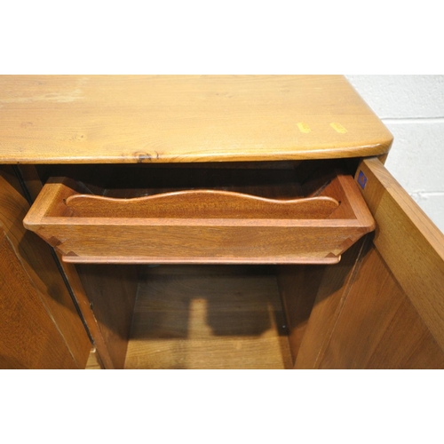 1433 - AN ERCOL MODEL 467 ELM AND BEECH SIDEBOARD, with double cupboard door above a single drawer, besides... 