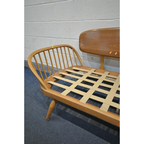 1435 - AN ERCOL MODEL 355 ELM AND BEECH STUDIO COUCH, with a surfboard back and spindled ends, with origina... 