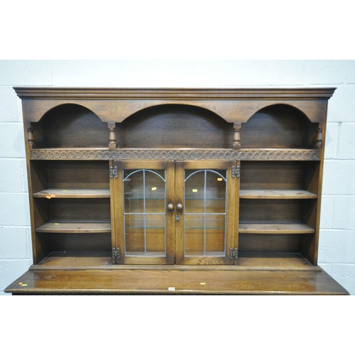 1458 - A REPRODUCTION OAK DRESSER, with an arrangement of cupboards and shelves, over a base with four draw... 