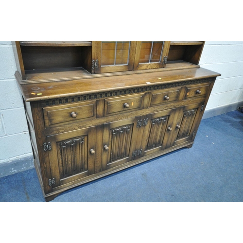 1458 - A REPRODUCTION OAK DRESSER, with an arrangement of cupboards and shelves, over a base with four draw... 