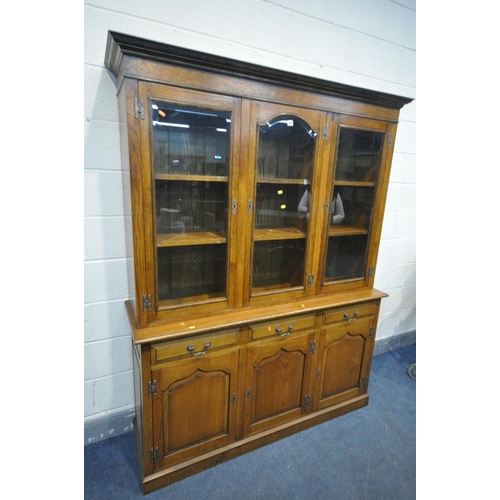 1459 - A REPRODUCTION OAK TRIPLE GLAZED DOOR BOOKCASE, with bevelled glass panels, enclosing six shelves, t... 