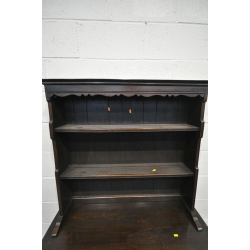 1460 - A SLIM REPRODUCTION OAK DRESSER, the top with a wavy apron with two plate rack shelves, two drawers,... 