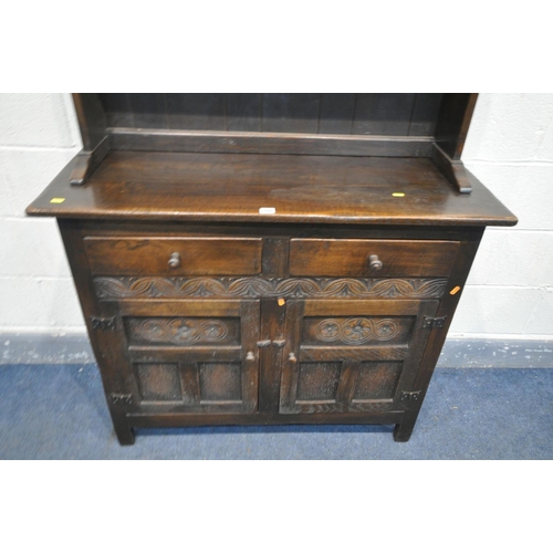 1460 - A SLIM REPRODUCTION OAK DRESSER, the top with a wavy apron with two plate rack shelves, two drawers,... 