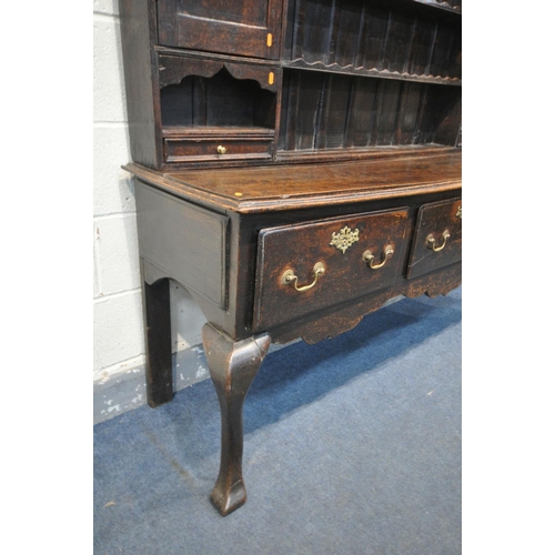 1548 - A GEORGIAN OAK DRESSER, the top with an arrangement of shelving flanked by a single cupboard, above ... 