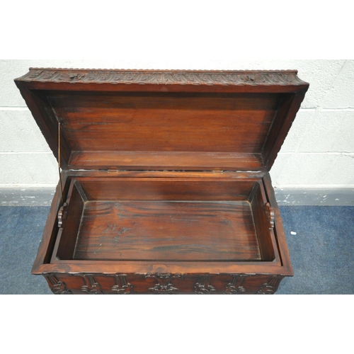 1580 - A HEAVILY CARVED HARDWOOD REPRODUCTION CHEST, with an internal removable tray and two dividers, leng... 