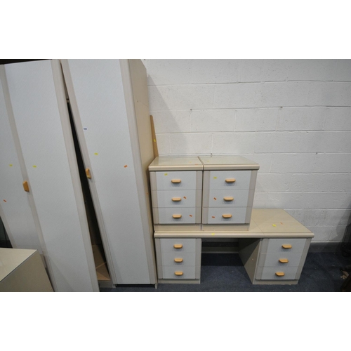 1606 - A CREAM FIVE PIECE BEDROOM SUITE, comprising a three door wardrobe, a desk with six drawers, a pair ... 