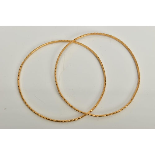 125 - TWO YELLOW METAL BANGLES, each with embossed detail, approximate inner diameter 61mm, stamped 22c, a... 