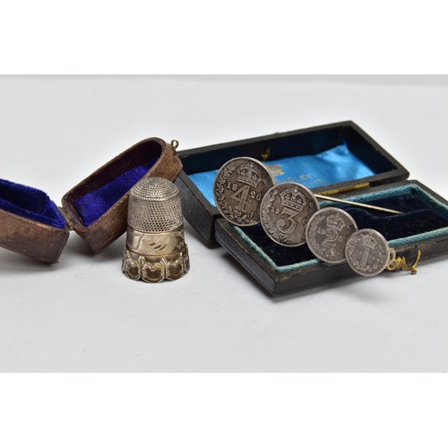 143 - A CASED EARLY 20TH CENTURY SILVER THIMBLE AND A CASED MAUNDY COIN BROOCH, the first with scroll and ... 