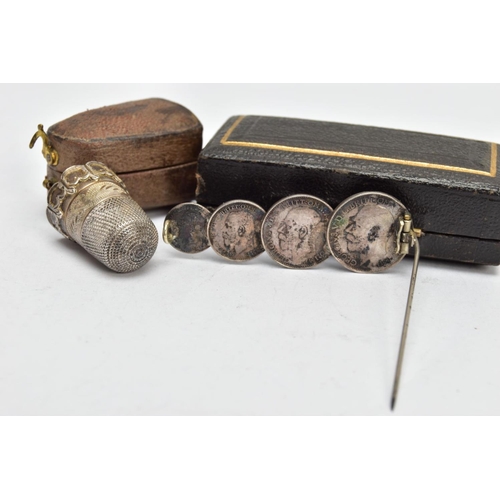 143 - A CASED EARLY 20TH CENTURY SILVER THIMBLE AND A CASED MAUNDY COIN BROOCH, the first with scroll and ... 