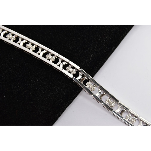 156 - A WHITE METAL DIAMOND OPENWORK BRACELET, with a trilogy of brilliant-cut diamonds each interspaced b... 