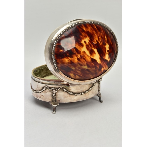 183 - AN EARLY 20TH CENTURY SILVER AND TORTOISESHELL HINGED BOX, the oval trinket box with embossed garlan... 