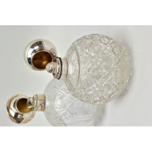 186 - TWO GLASS SILVER TOPPED PRESSED BOTTLES, each designed as a rounded glass bottle with silver tops an... 