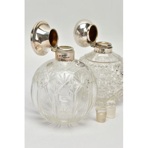 186 - TWO GLASS SILVER TOPPED PRESSED BOTTLES, each designed as a rounded glass bottle with silver tops an... 