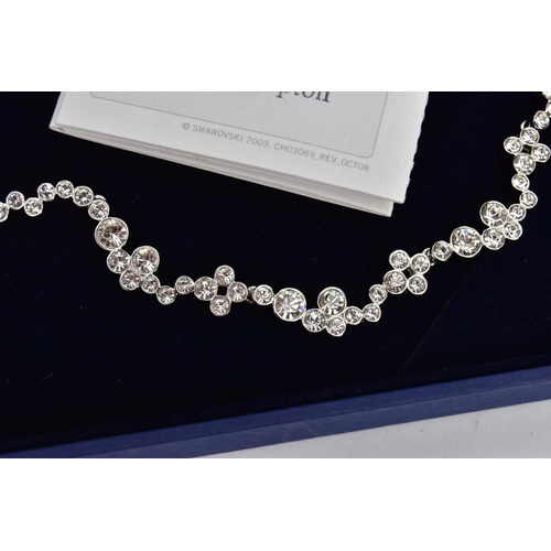 33 - A BOXED SWAROWSKI CRYSTAL NECKLACE, wavy detailed necklace with bezel set colourless crystals, adjus... 