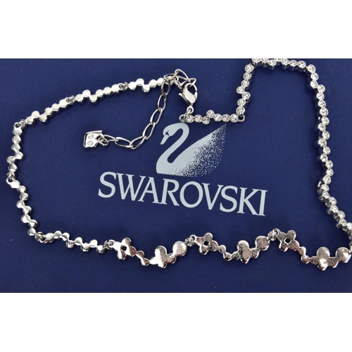 33 - A BOXED SWAROWSKI CRYSTAL NECKLACE, wavy detailed necklace with bezel set colourless crystals, adjus... 