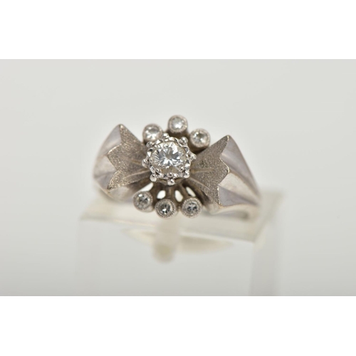 56 - A WHITE METAL DIAMOND RING, abstract bow style ring set centrally with a round brilliant cut diamond... 