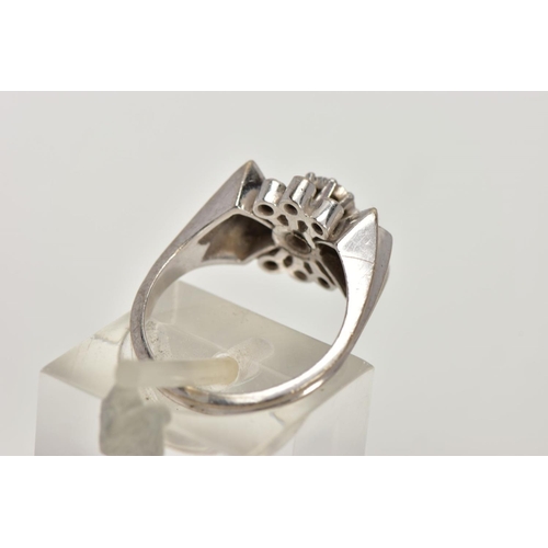 56 - A WHITE METAL DIAMOND RING, abstract bow style ring set centrally with a round brilliant cut diamond... 