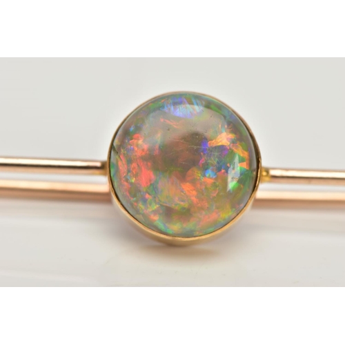 62 - AN OPAL BAR BROOCH, a circular cut opal cabochon, extensive colour play showing flashes of green, bl... 